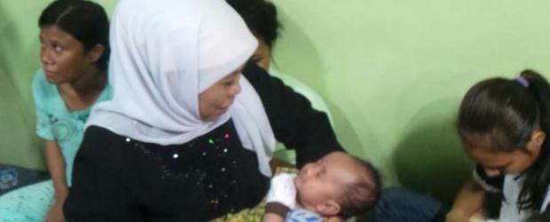 Menteri Sosial Khofifah Indar Pawaransa menggendong salah satu bayi dari TKI yang bermasalah (Foto: Kompas.com/ Indra Akuntono)