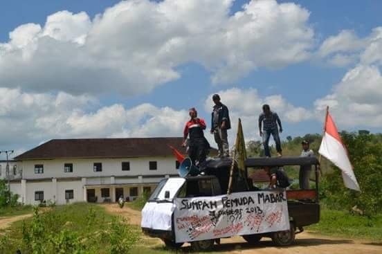Tampak bangunan RSUD Mabar di Marombok yang mubazir (di belakang para pendemo)