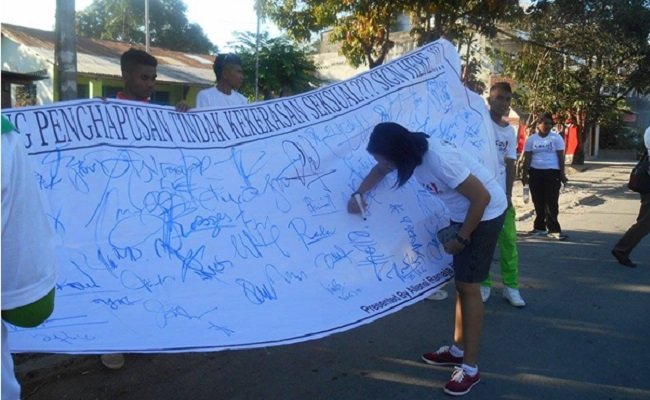 Seorang peserta jalan sehat memberitakan tanda tangannya sebagai bentuk komitmen menyatakan penolakan terhadap tindak kekerasan seksual