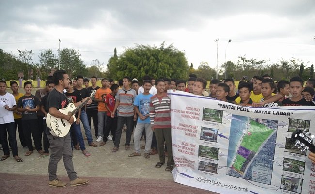 Para remaja bernyanyi di depan kantor bupati Manggarai Barat menegaskan sikap mereka menolak privatisasi Pantai Pede