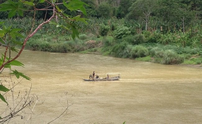 Umat menyeberangi sungai Wae Pesi untuk bisa sampai ke Kapel Stasi Nggorang, Reo