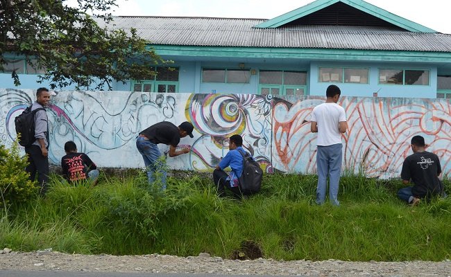 Komunitas Ngkiong Art sedang melukis pagar tembok kantor Badan Kepegawaian Daerah Manggarai, Senin