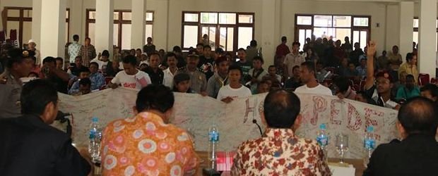 Peserta sosialisasi membentangkan spanduk di depan tim Pemprov NTT, berisi pernyataan penolakan penyerahan pengelolaan pantai itu ke pihak swasta.