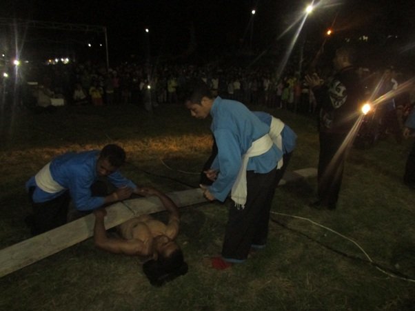 Salah seorang anggota THS/THM berbaring dan di atasnya dipasang papan yang dipasang paku, dengan bagian lancip menghadap ke tubuhnya. (Foto: Evan Lahur/Floresa)