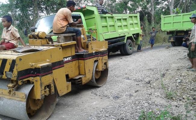 Kendaraan milik CV Sinar Lembor Indah sedang mengerjakan kembali jalan ini, meski masa pemeliharaan sebenarnya sudah selesai. (Foto: Ferdinan Ambo/Floresa)