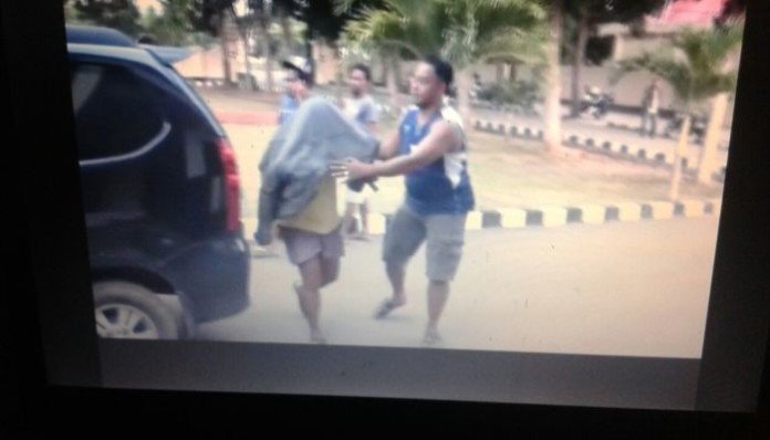 Dalam foto ini tampak anggota DPRD Mabar Edi Endi yang menutup kepalanya dan sedang digiring ke mobil polisi