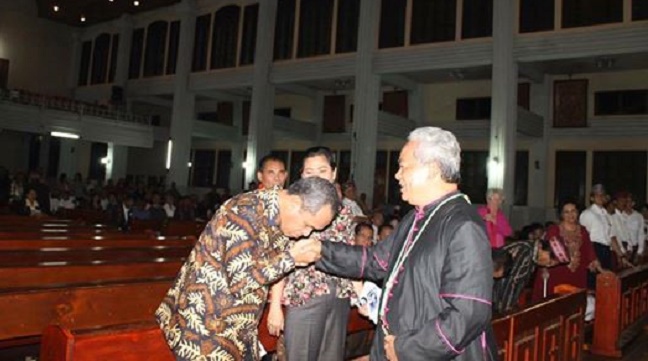 Beny Kabur Harman mencium cincin Uskup Sorong Mgr Datus Lega usai perayaan ekaristi memperingati satu tahun kepergian almarhum Ben Mboi di Katedral Ruteng, Jumat, 24 Juni 2016. (Foto: Facebook Lexi Armanjaya)