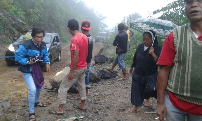 Beberapa suster dan para pejabat yang melintasi jalan menuju Elar terpaksa harus keluar dari mobil agar kendaraan mereka itu bisa melewati bagian jalan yang rusak parah. (Foto: Ferdinand Ambo/Floresa)