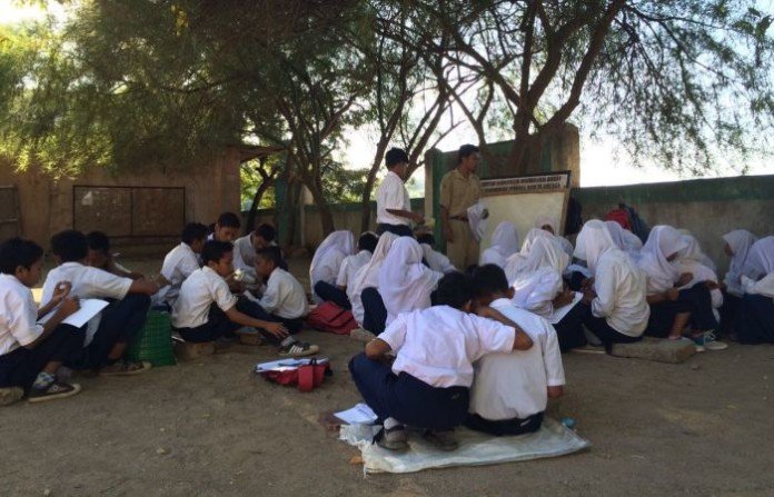 Para murid SMP Negeri Satu Atap di Pulau Komodo yang hingga kini hanya memiliki satu ruang kelas, sehingga terpaksa ada kelas yang melaksanakan kegiatan belajar mengajar di bawah pohon.